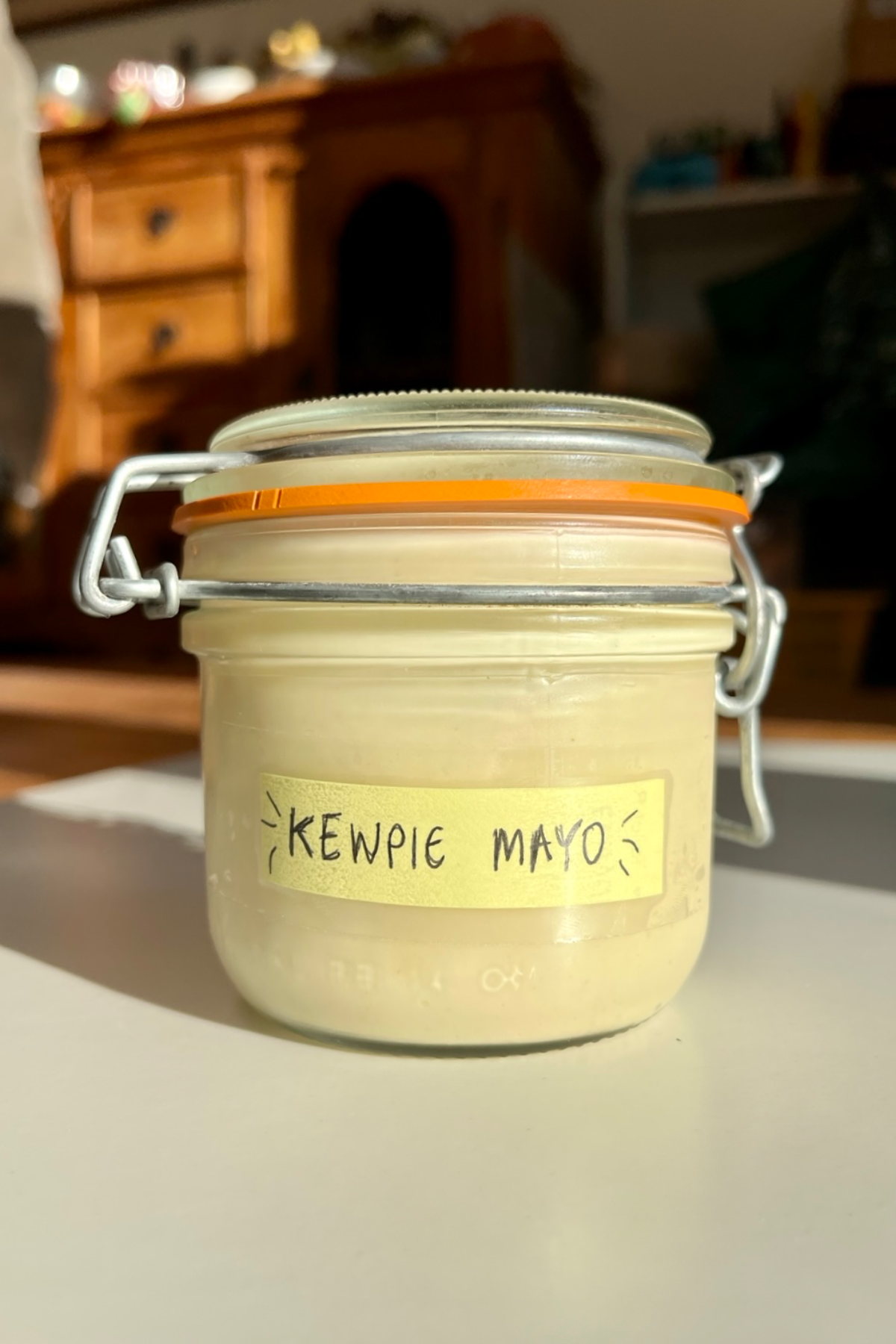 Glass jar with a label saying kewpie mayo on it. 