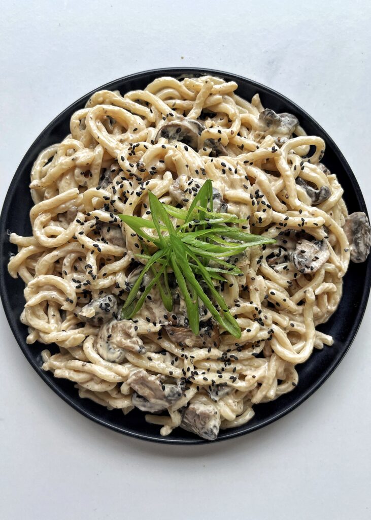 Creamy udon dish on a black plate
