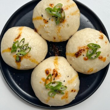 coconut bao (steamed buns) topped with spring onion and chilli oil.