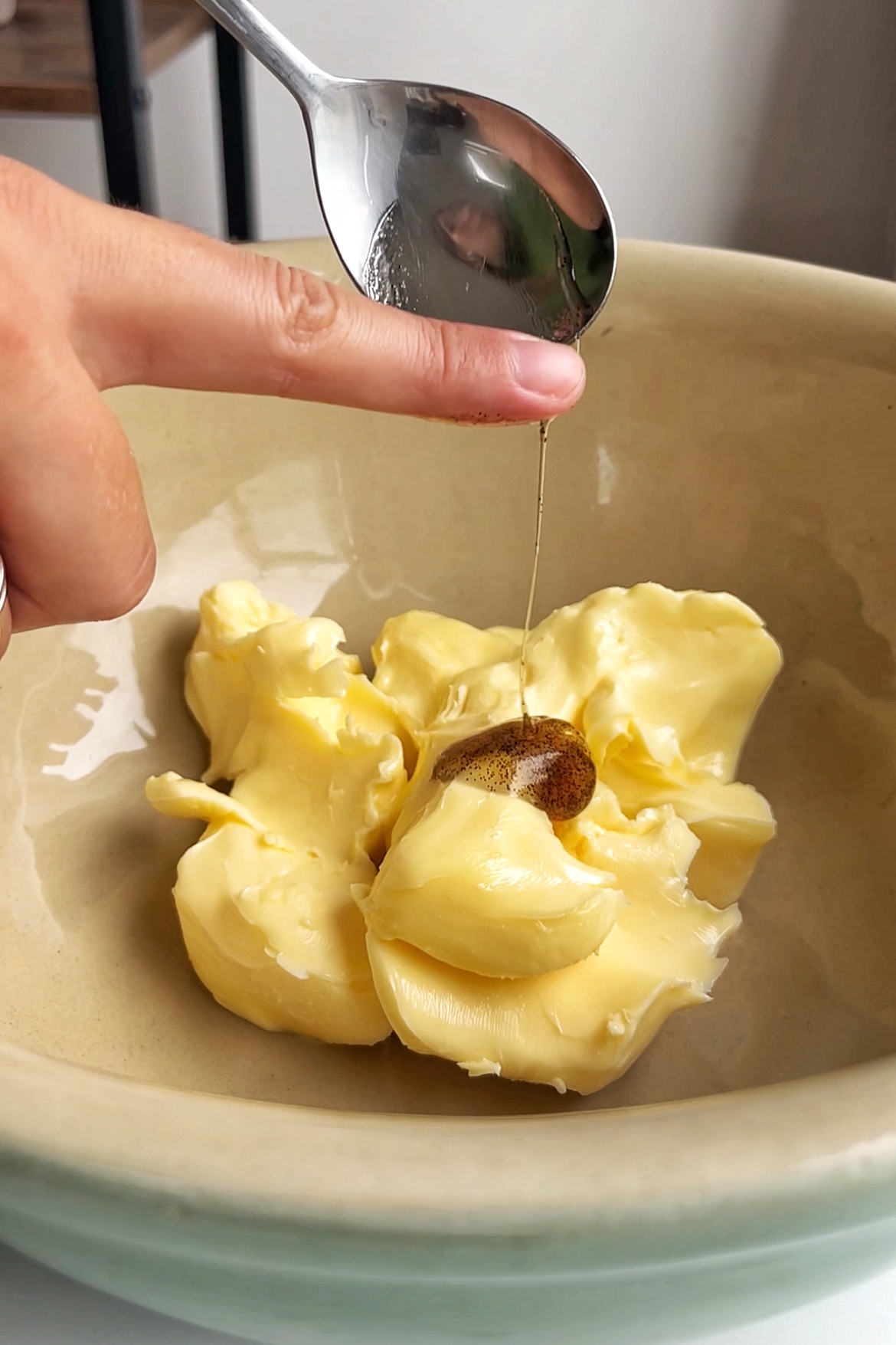 Adding vanilla paste into a butter mixture.