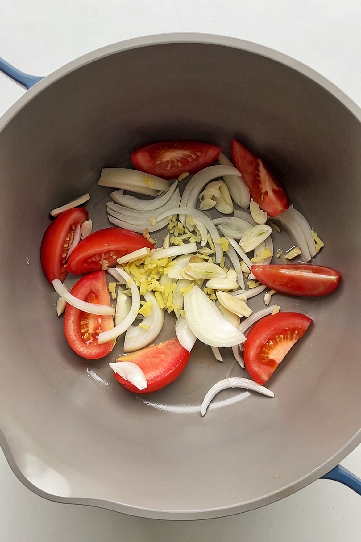 Frying tomato, onion, garlic, and ginger. 