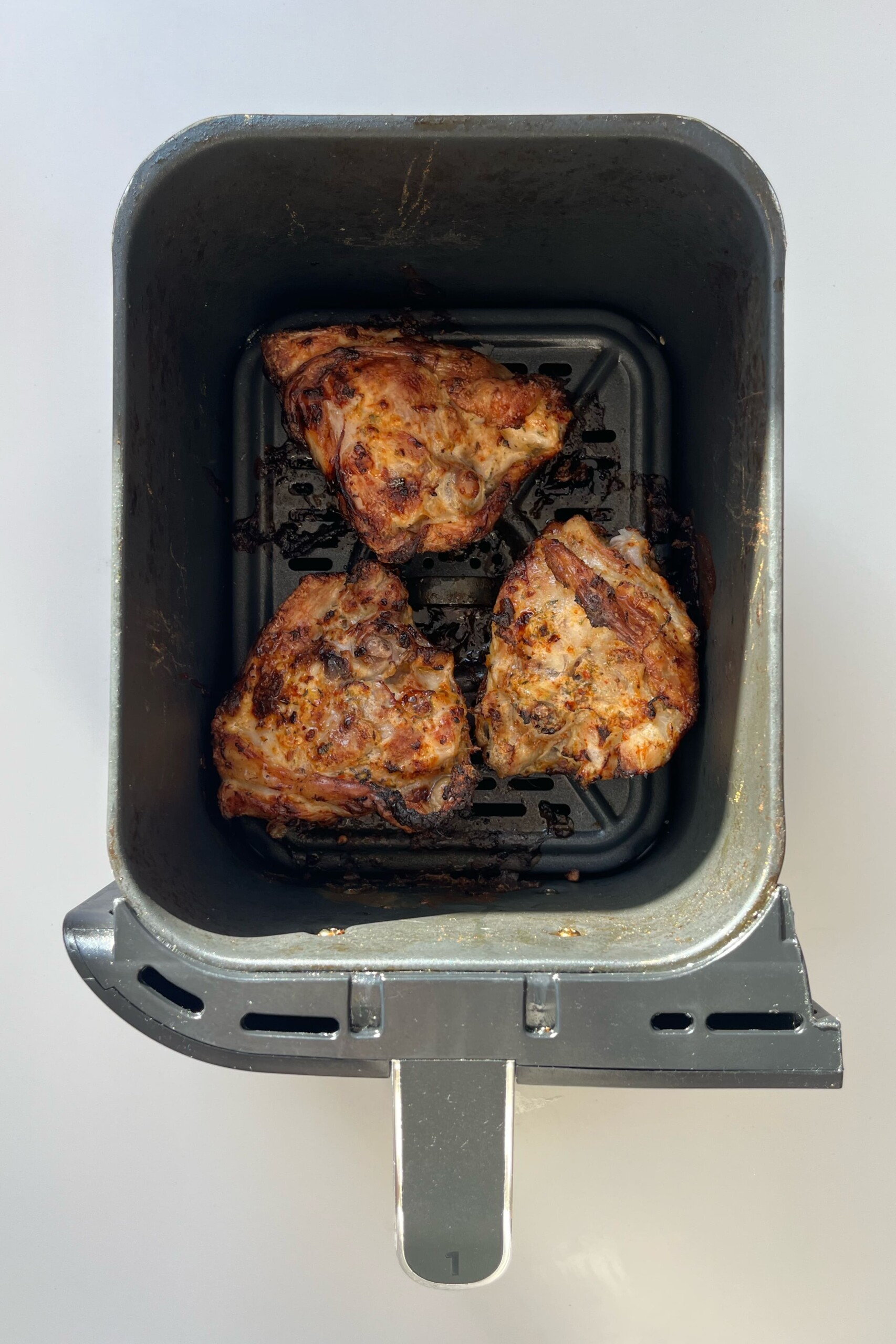 Cooked air fryer chicken in the air fryer compartment.