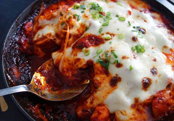 Fire chicken with gochujang topped with melted cheese.
