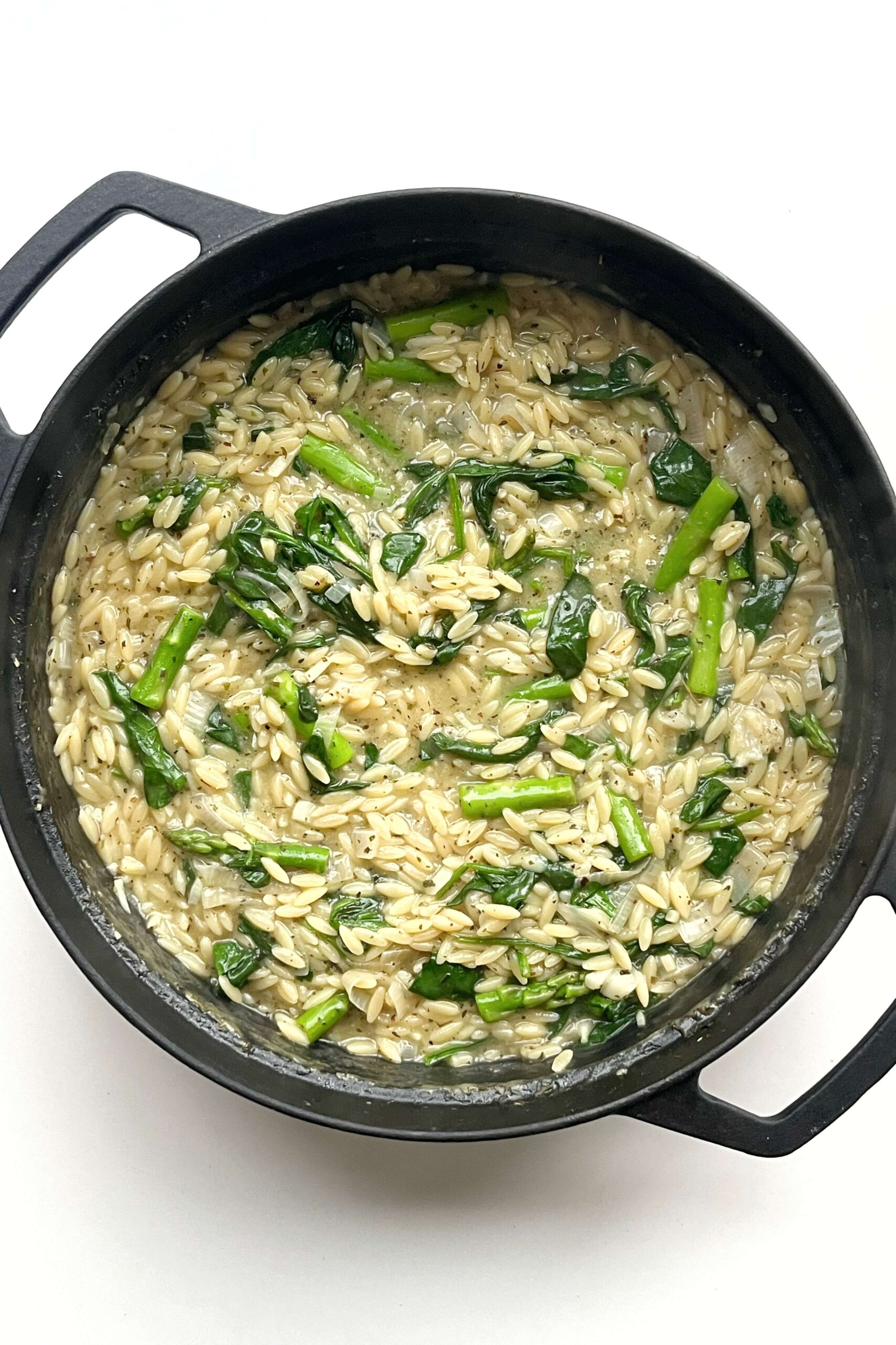 Asparagus orzotto in black pan. 