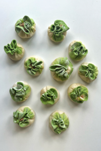 green and white dumplings on a white background.