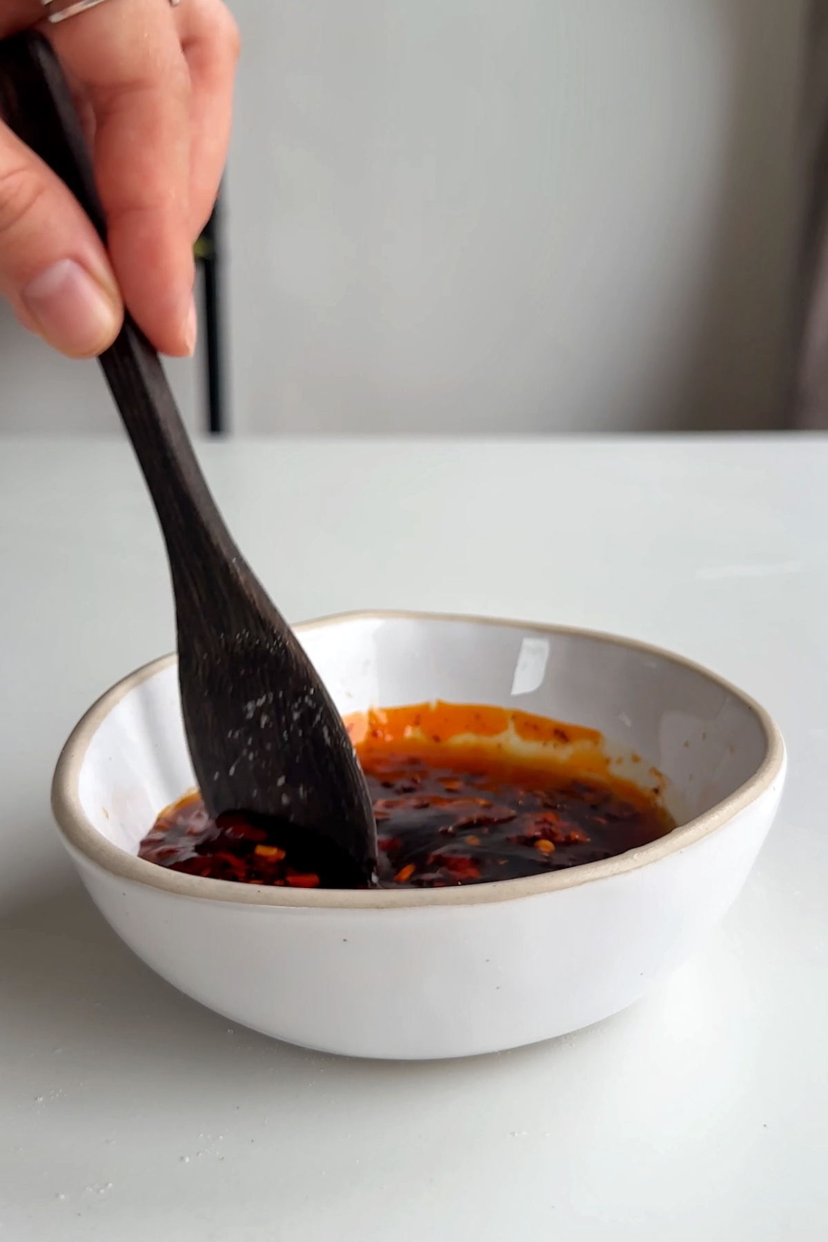 Stirring a sauce in a white bowl. 