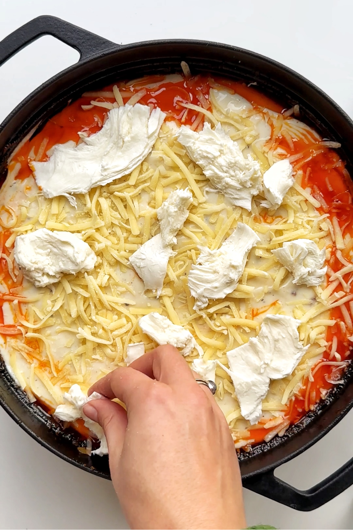 Topping the gochujang gnocchi lasagne with mozzarella cheese.
