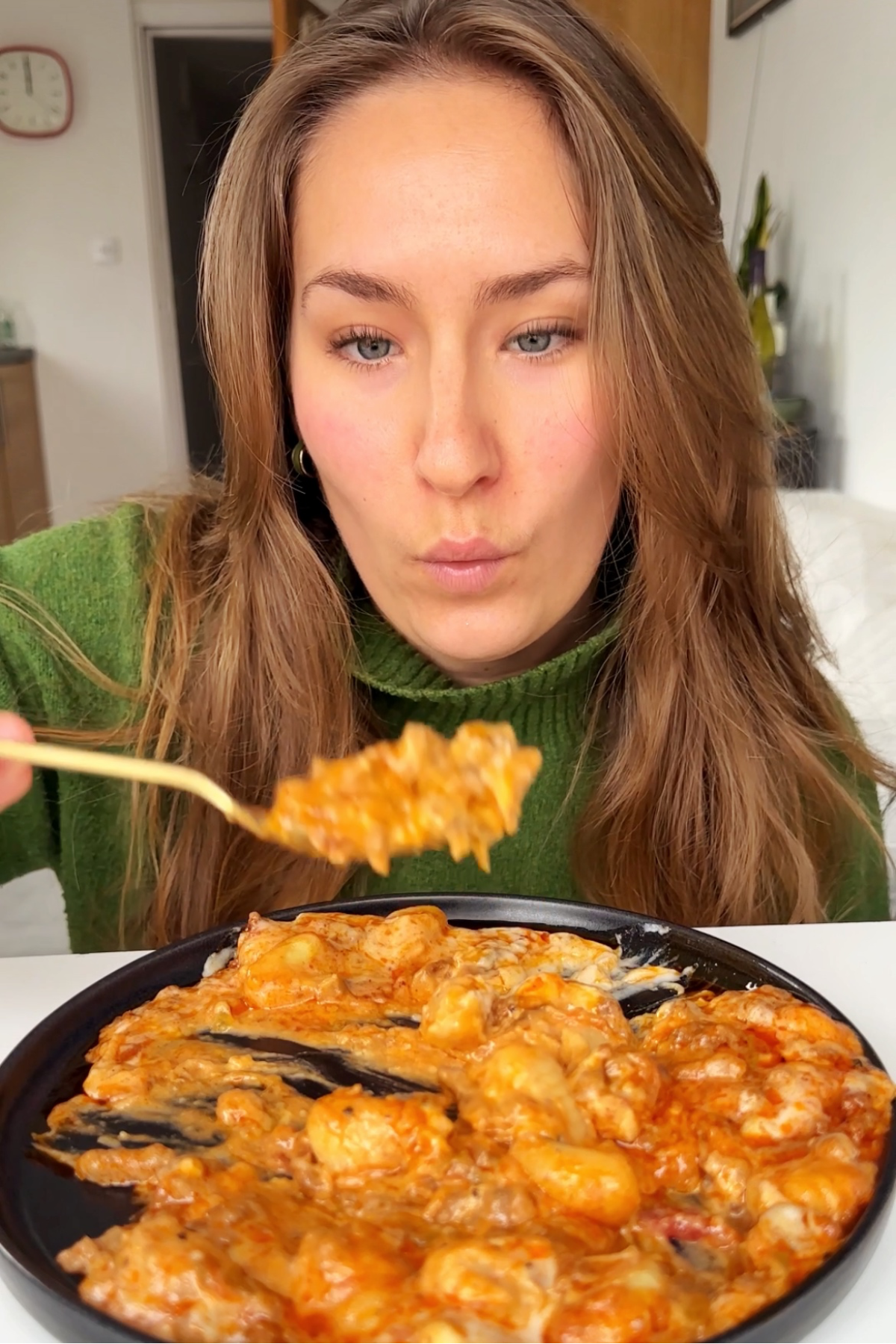 Emily Roz looking lovingly at a spoonful of gochujang gnocchi.