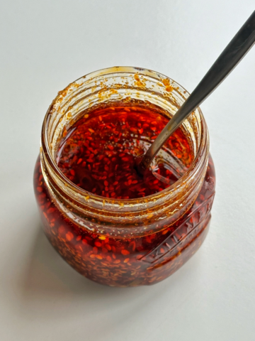 Glass jar with chilli oil in it.