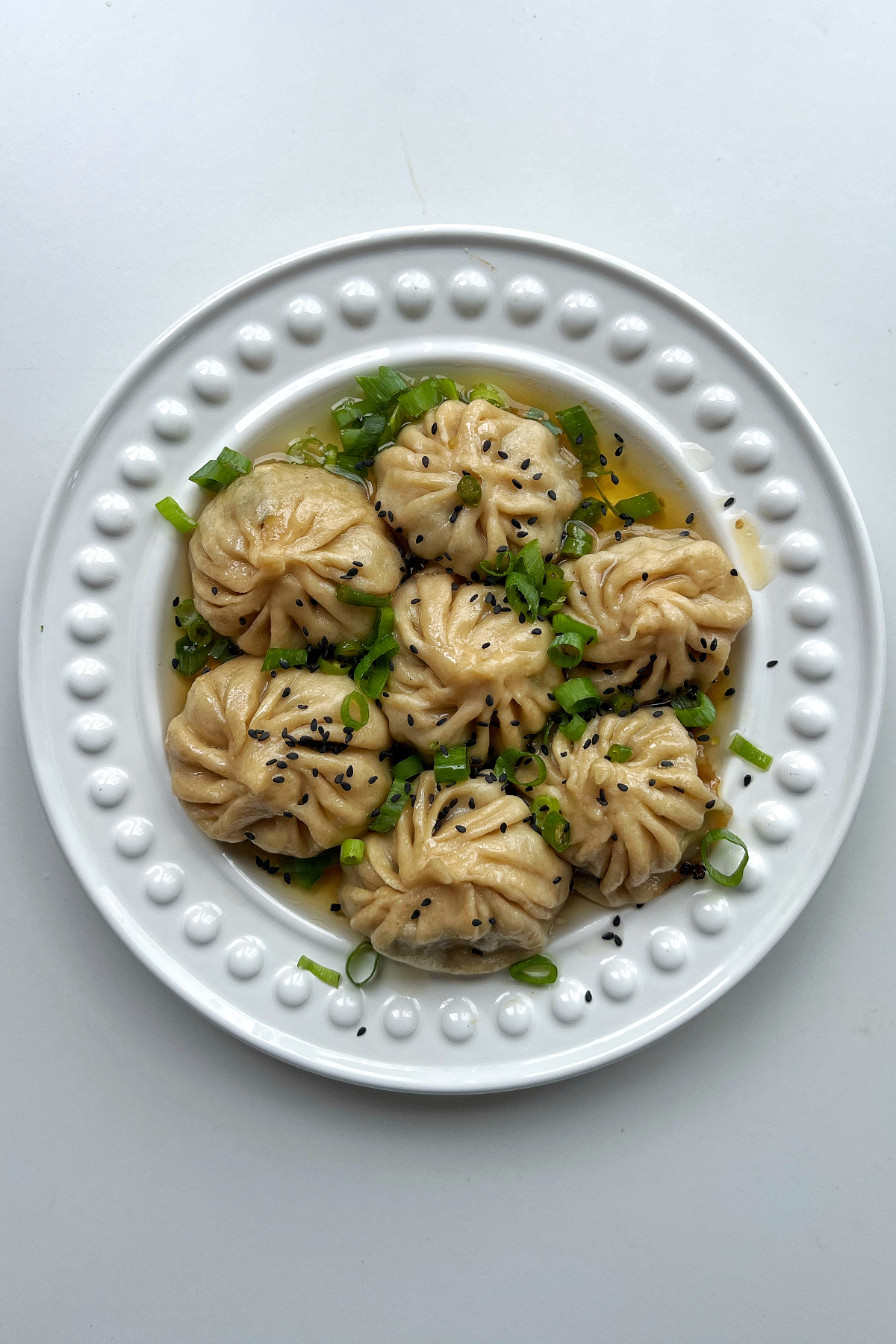 Pan fried lemongrass and beef dumplings on a white plate. 