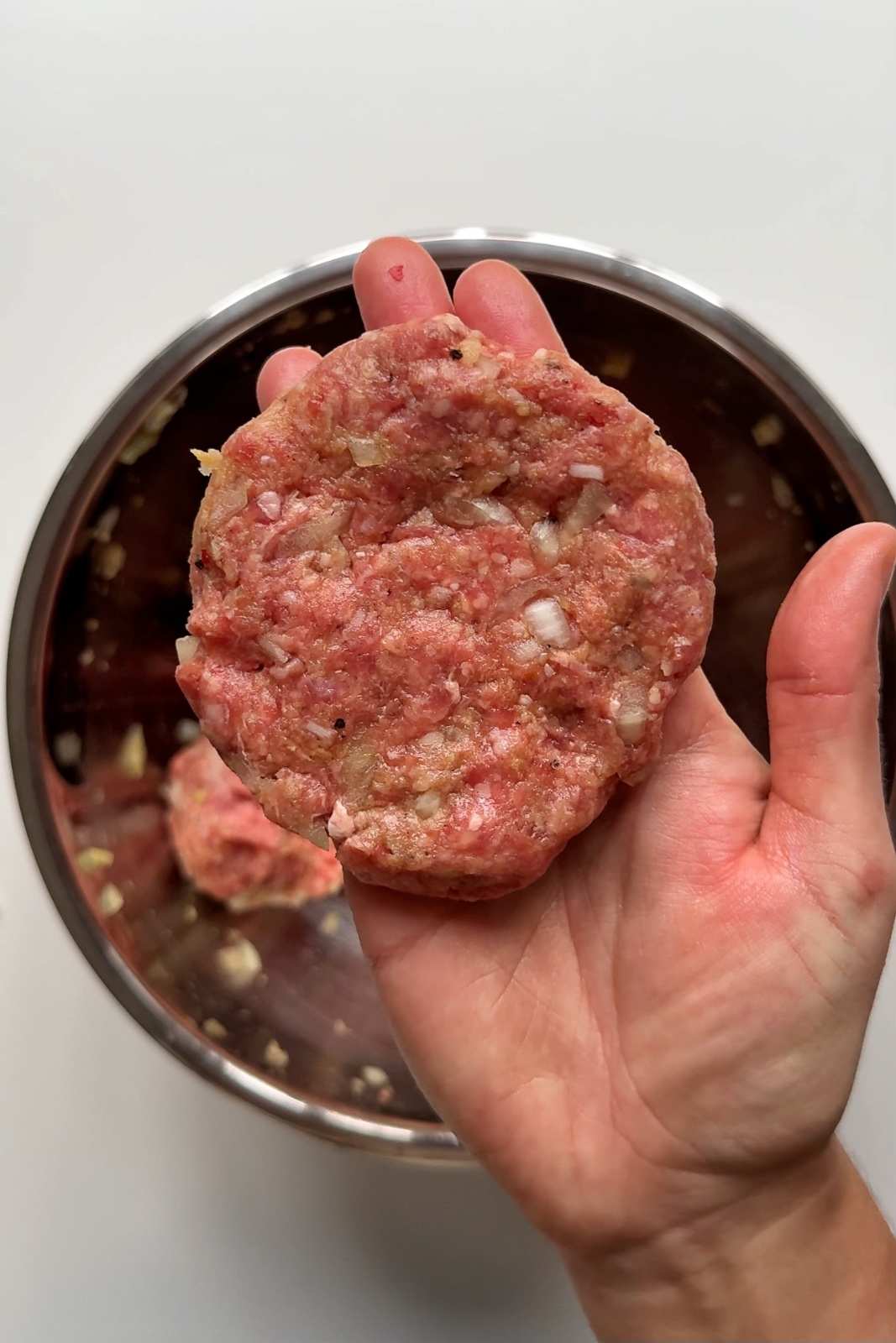 making burger patty with metal bowl.
