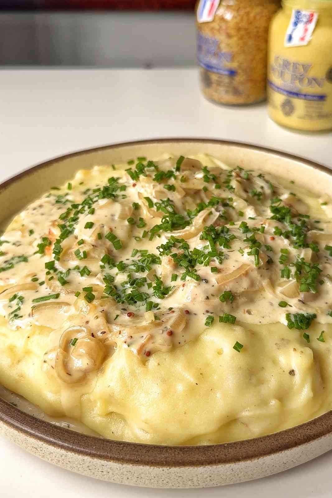 dijon mustard chicken on a bed of mashed potato.