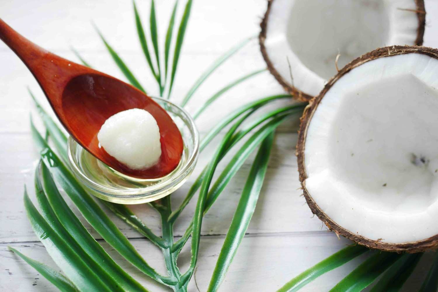A wooden spoon with a dollop of coconut oil being used as a ghee substitute