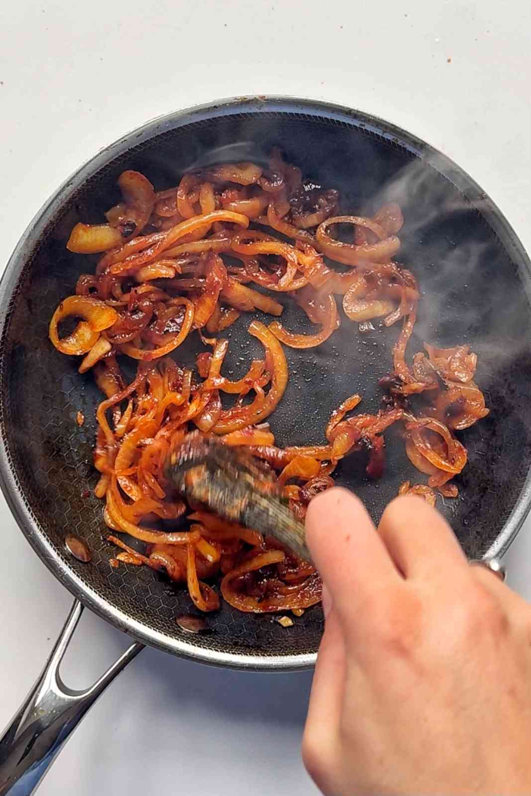 caramelised onions with harissa in pan.