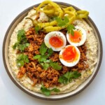 chicken hummus bowl with jammy eggs on a white background.