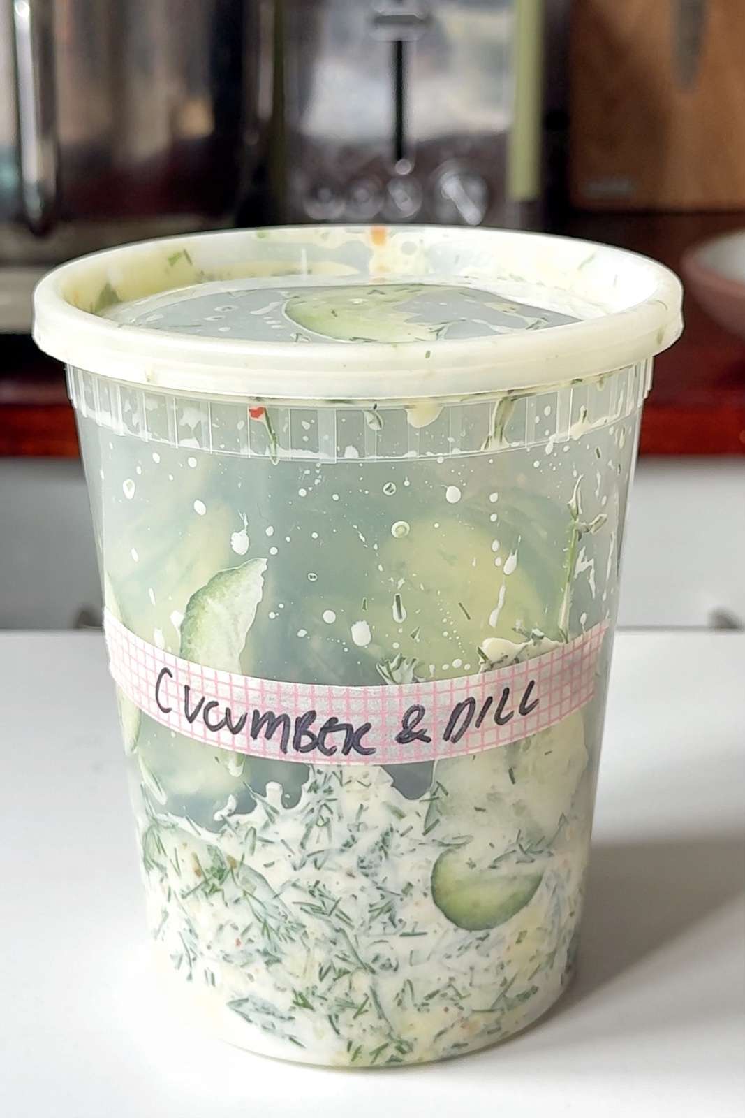 Cucumber dill salad in a tupperware.
