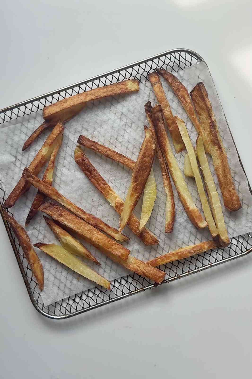 Golden crispy air fried French fries on an air fryer tray