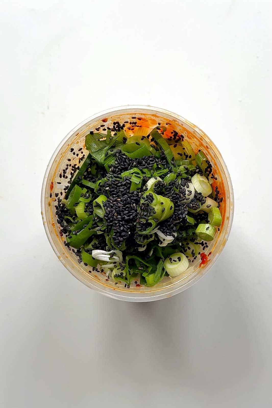 Plastic tupperware filled with cucumbers.