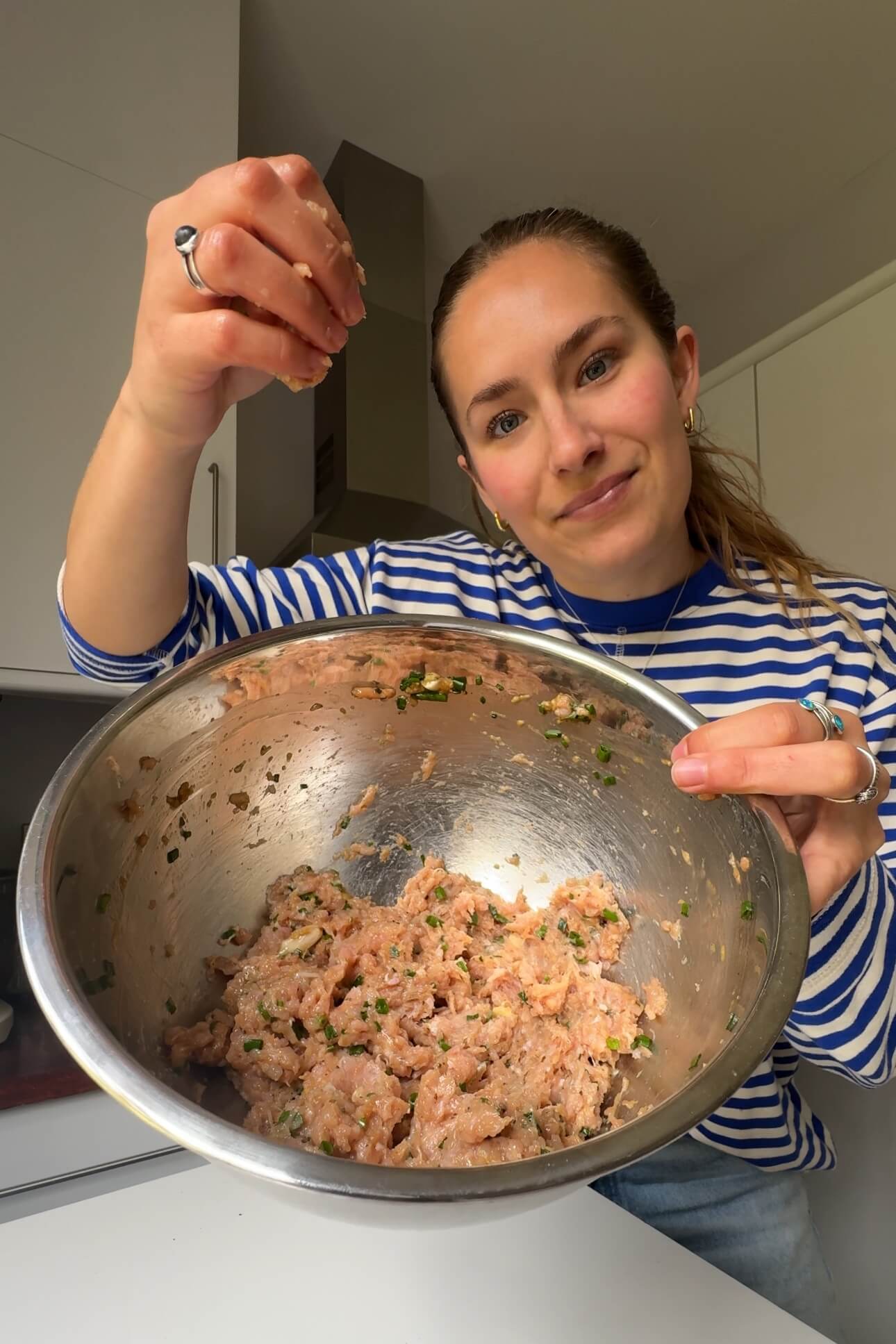 Emily Roz making blanket dumpling filling in metal bowl.