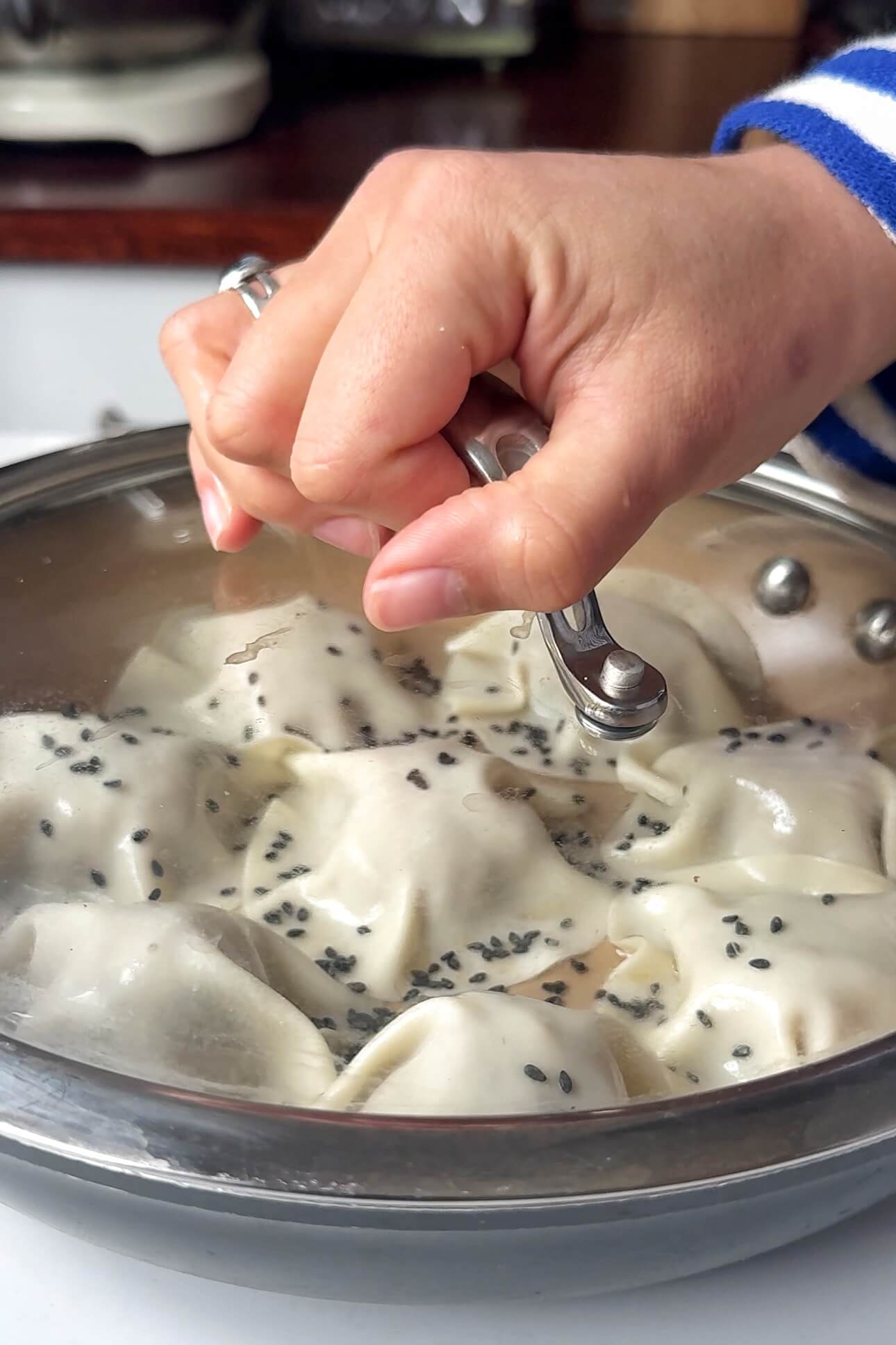 Covering pan with lid to steam blanket dumplings.