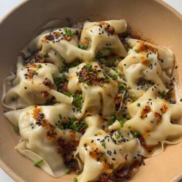 Blanket dumplings topped with chives and chilli oil.