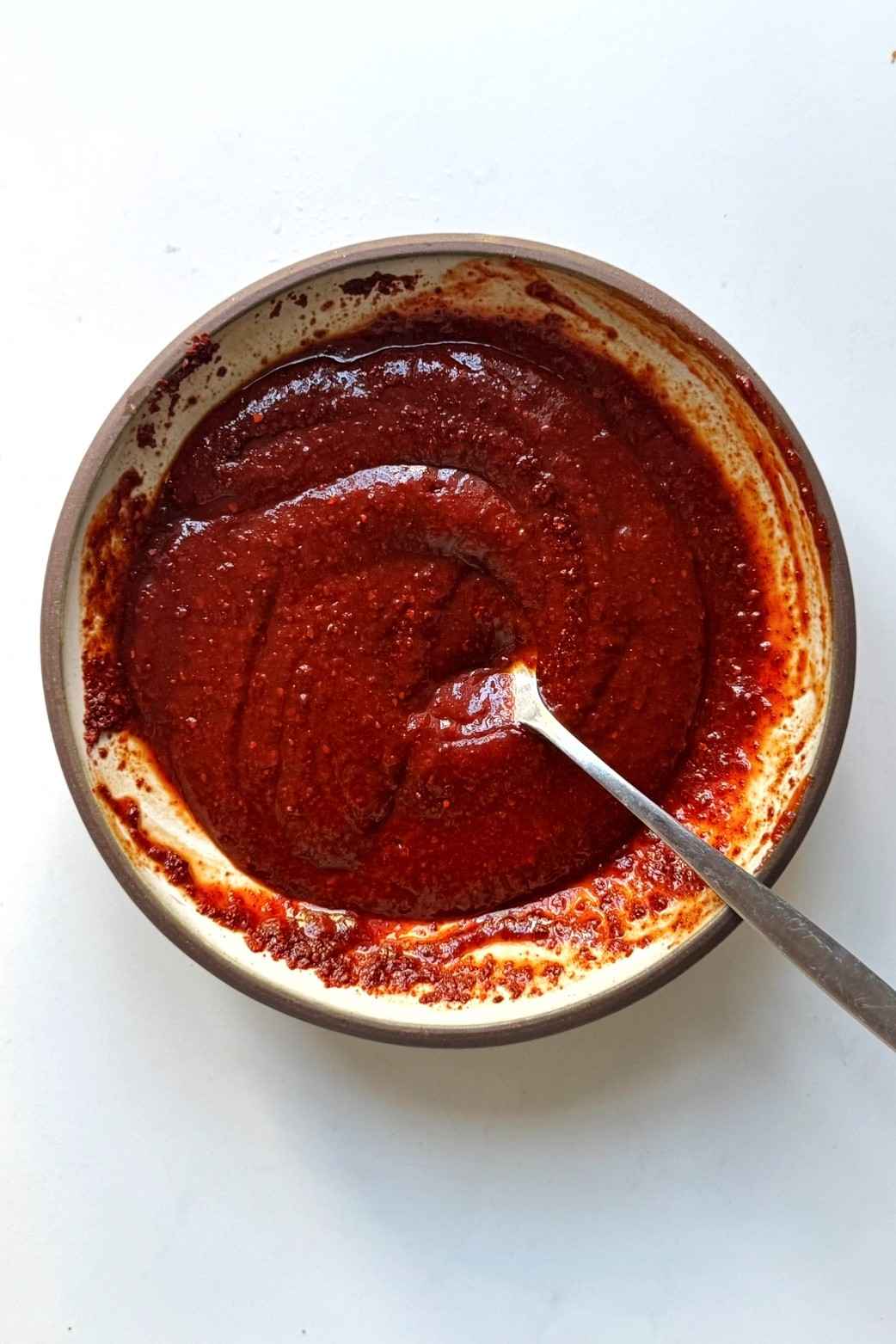 Spicy gochujang paste in a small ceramic bowl.