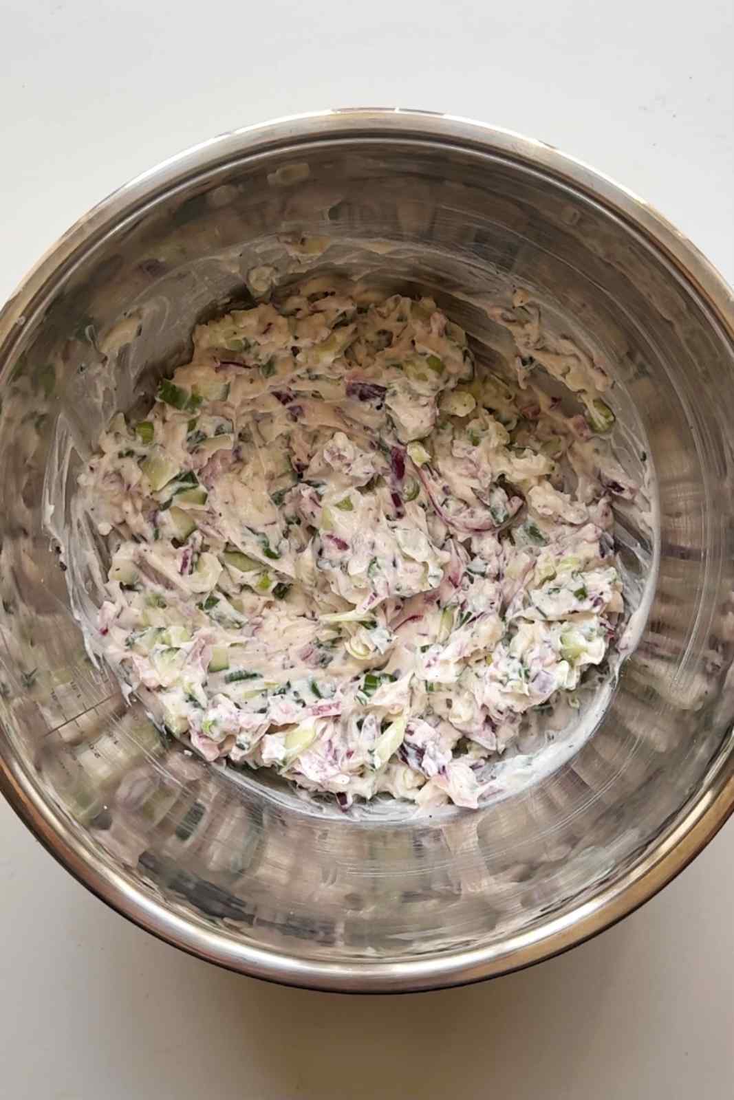 Making the crispy potato salad dressing in a stainless steel bowl.