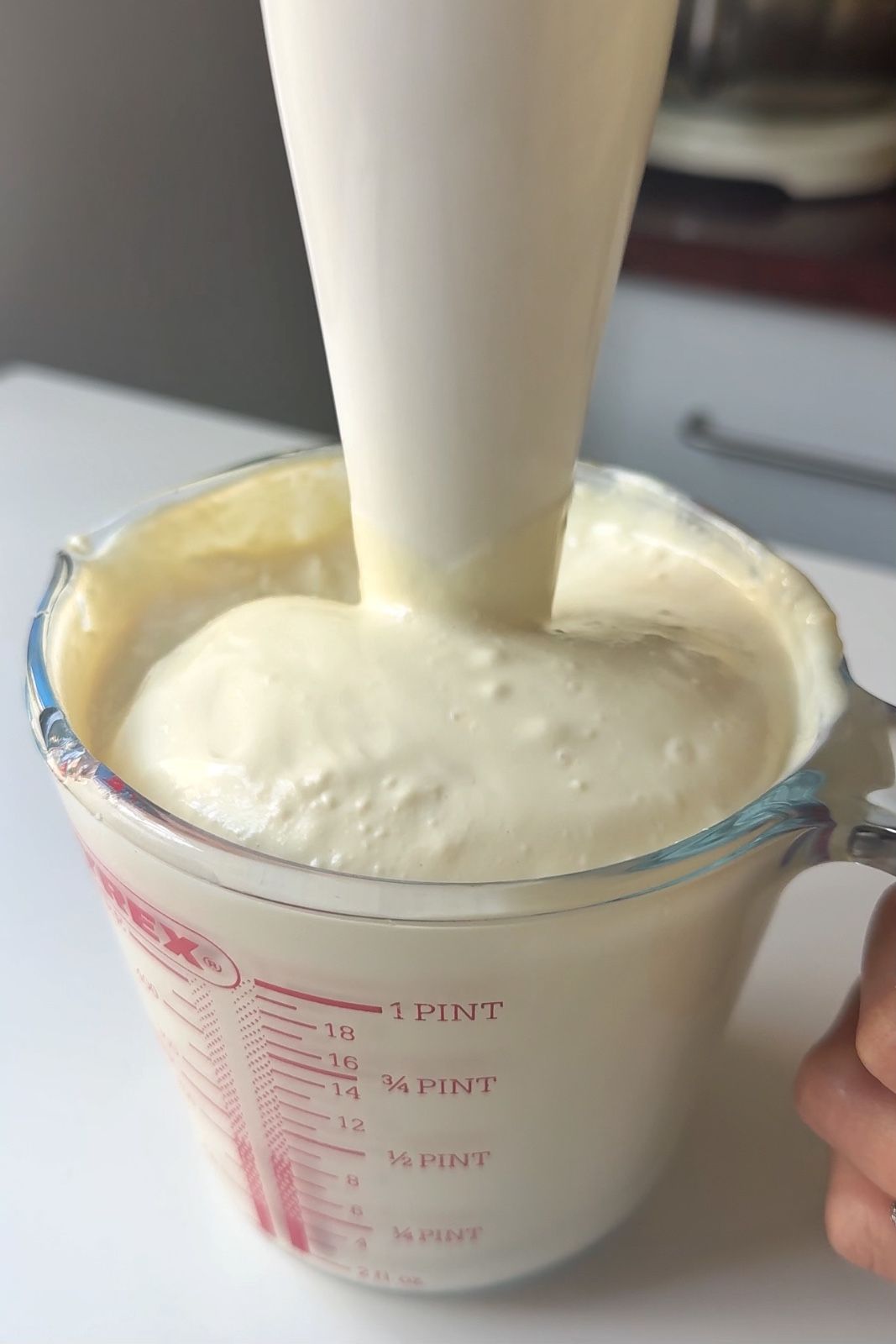 Blending silken tofu in a jug with a hand blender.