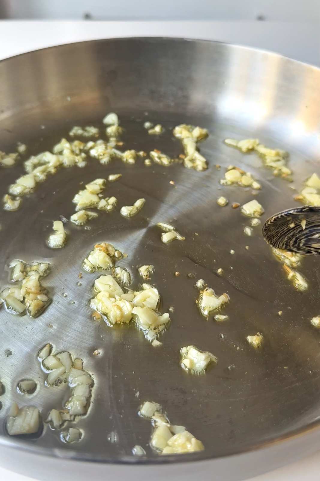 Frying garlic in a stainless steel skillet.