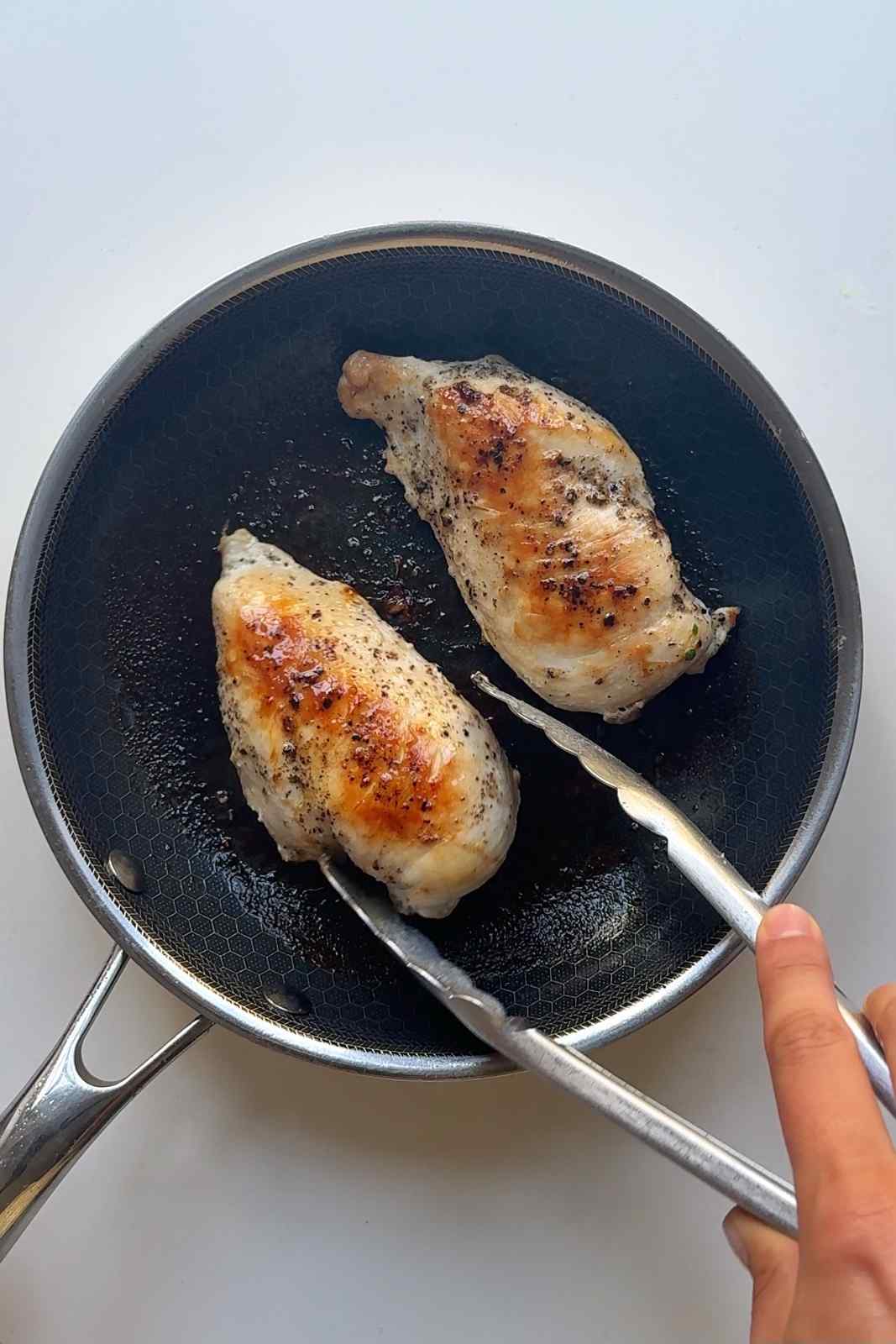 Frying chicken breast in pan.