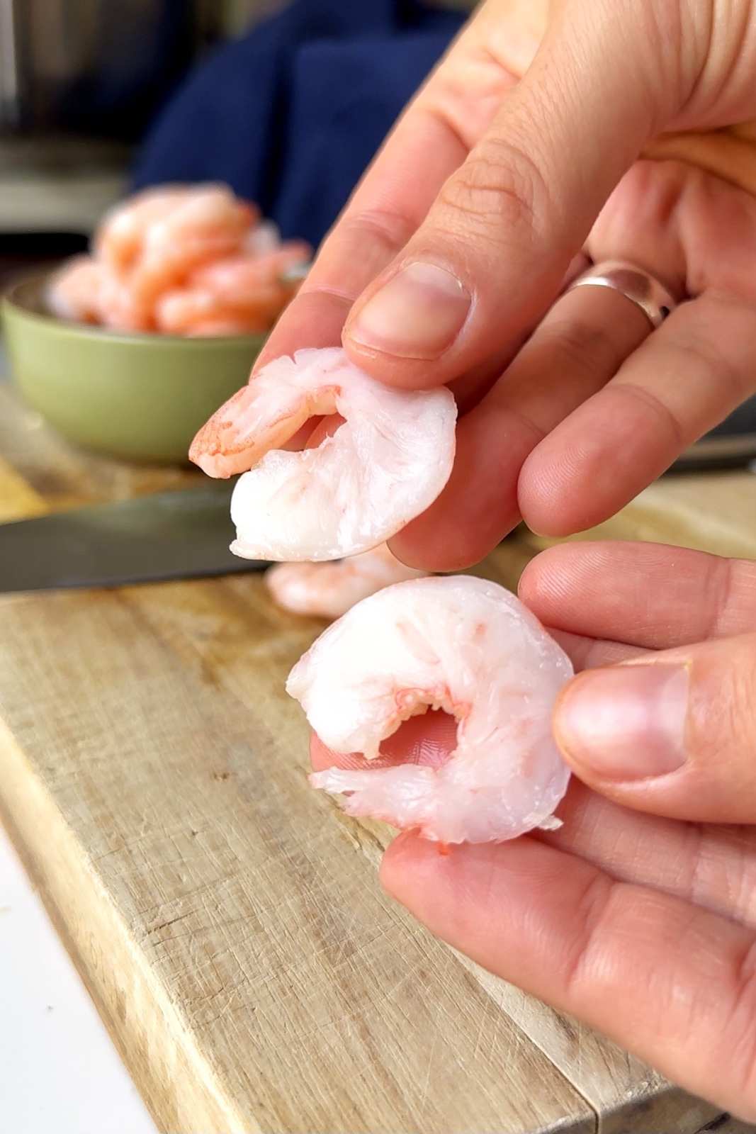 Slicing prawns in half lengthways.