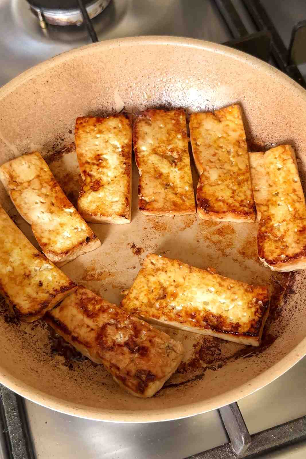 Frying strips of tofu in a pan.