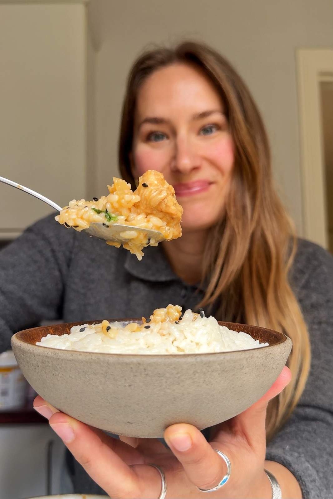 Emily Roz holding up a spoonful of curry to the camera.