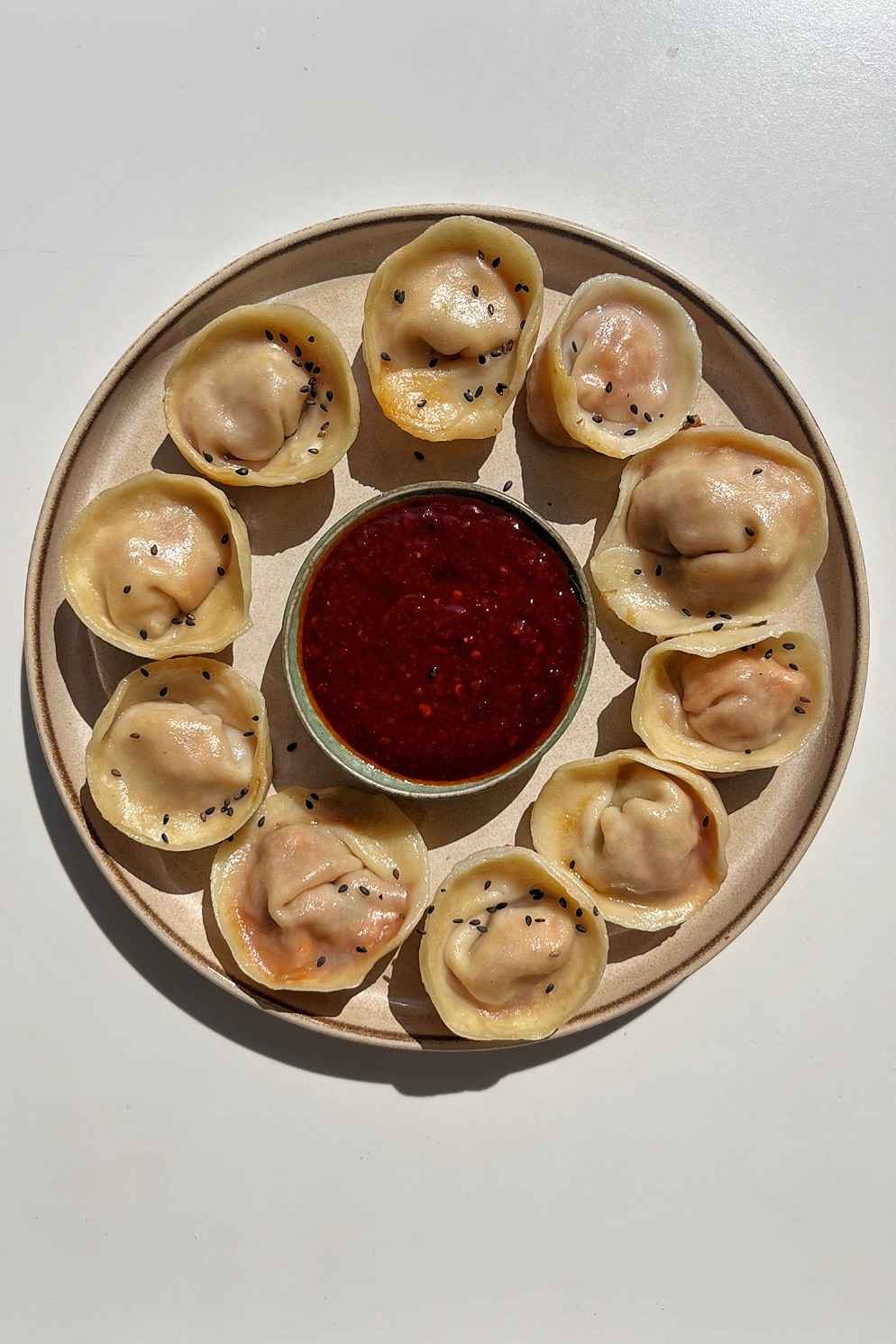 Kimchi tofu Korean mandu dumplings with crispy bottoms and visible kimchi-tofu filling on a cream plate with gochujang dipping sauce.
