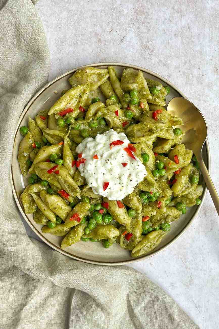 Scissor-cut tofu pasta in a vegan pesto sauce with peas and cottage cheese, a high-protein silken tofu dinner.