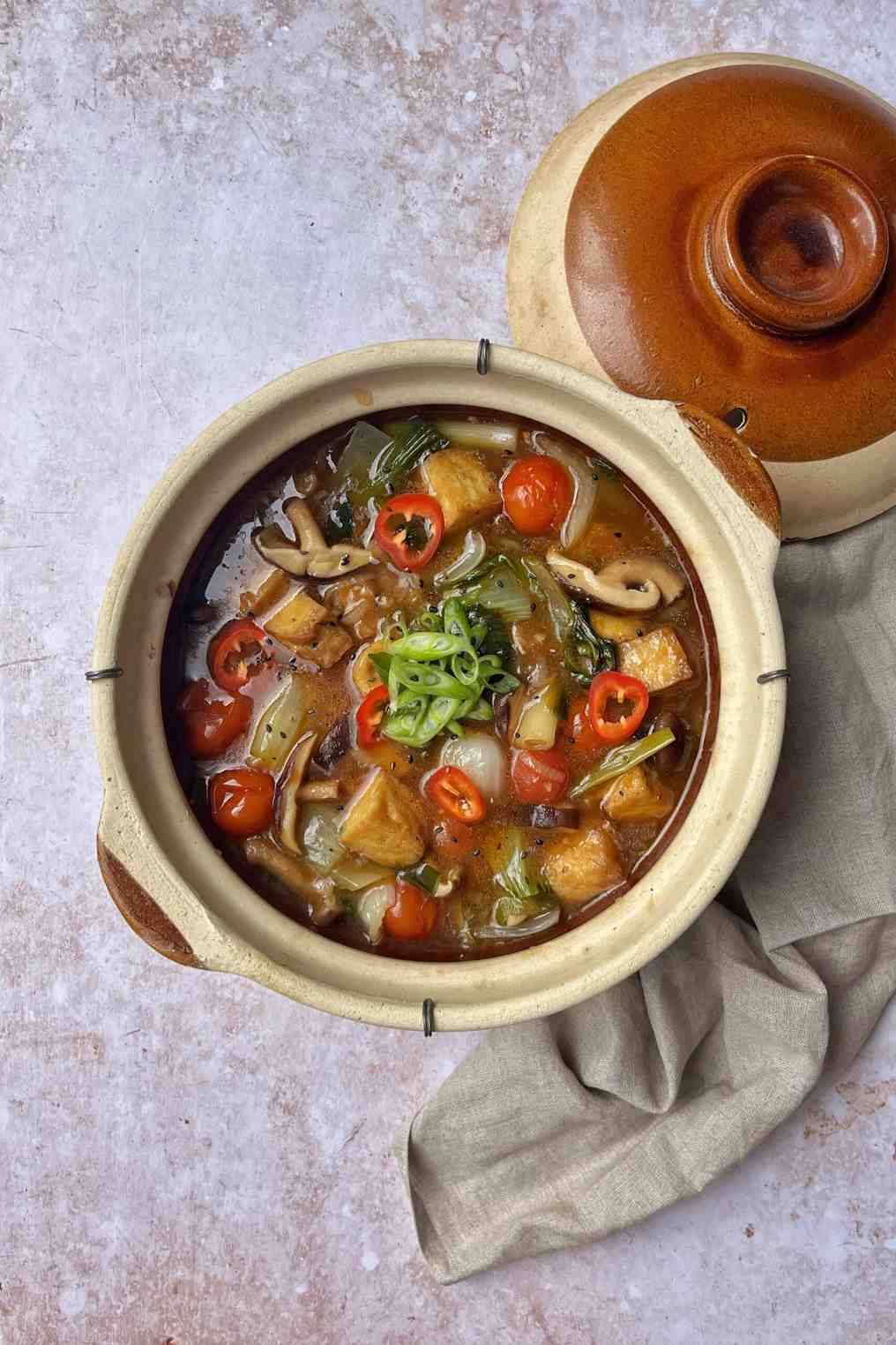 Claypot tofu with silken tofu, shiitake mushrooms, pak choi, cherry tomatoes and scallions in a glossy soy sauce, a 20-minute silken tofu recipe.