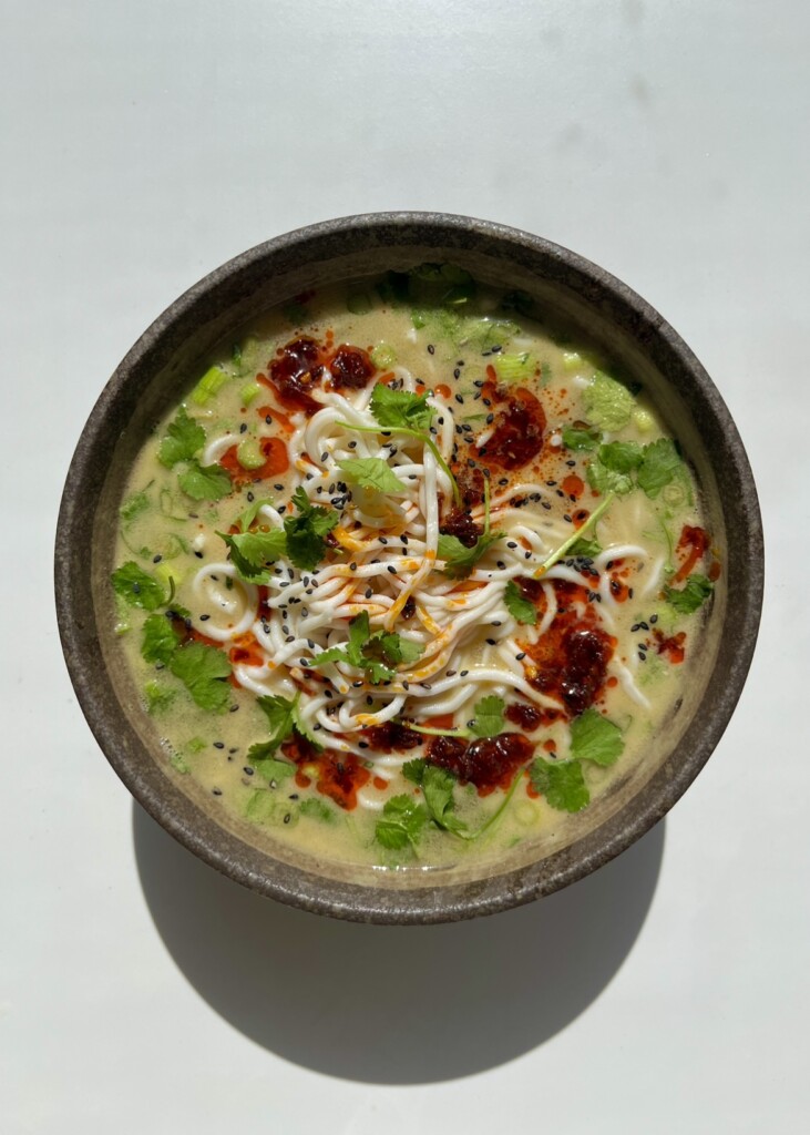 A bowl of easy 10-minute noodle soup topped with chili oil, cilantro, and scallions.