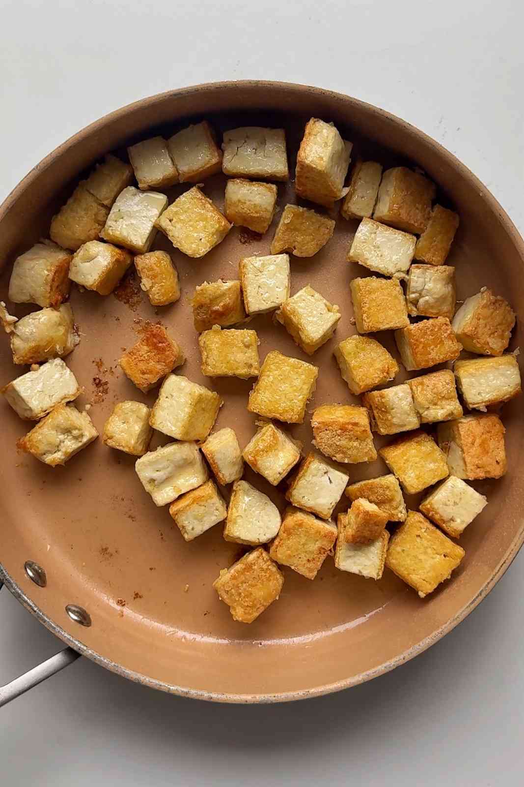 Frying tofu in a skillet.