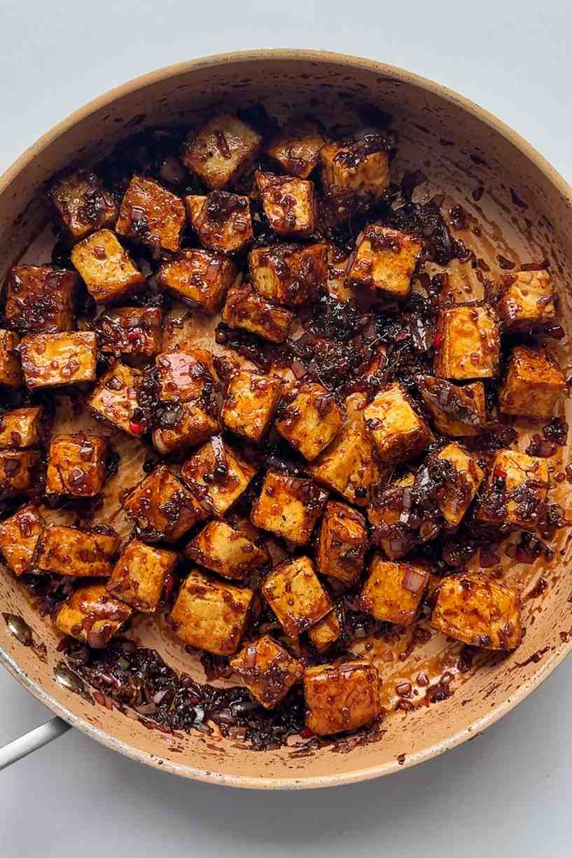 Black pepper tofu in skillet on white background.