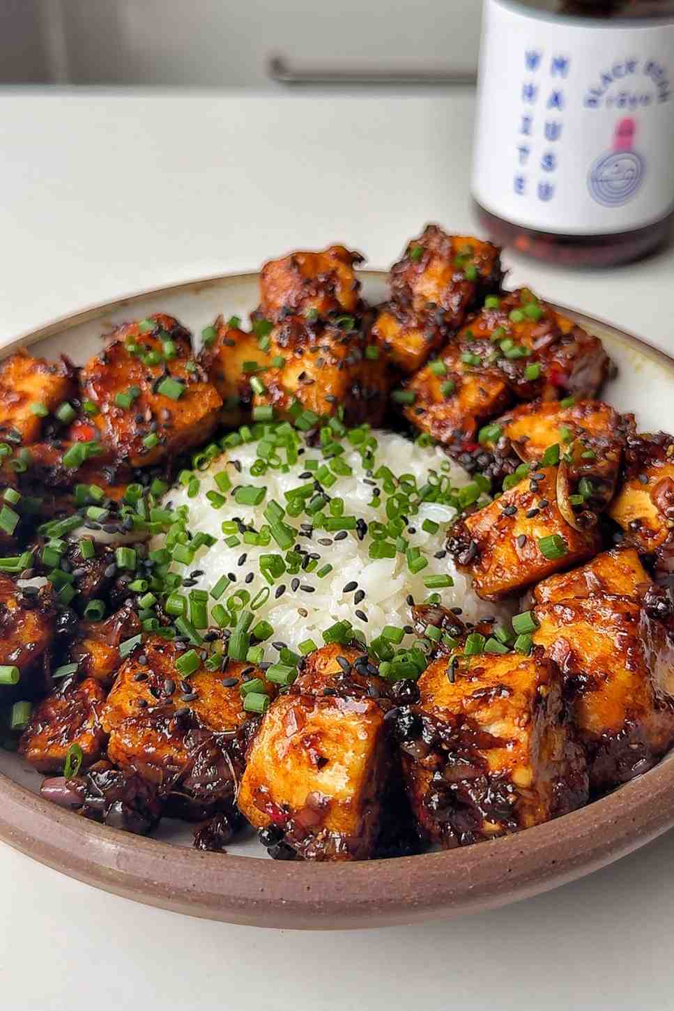 Black pepper tofu with rice in a bowl.