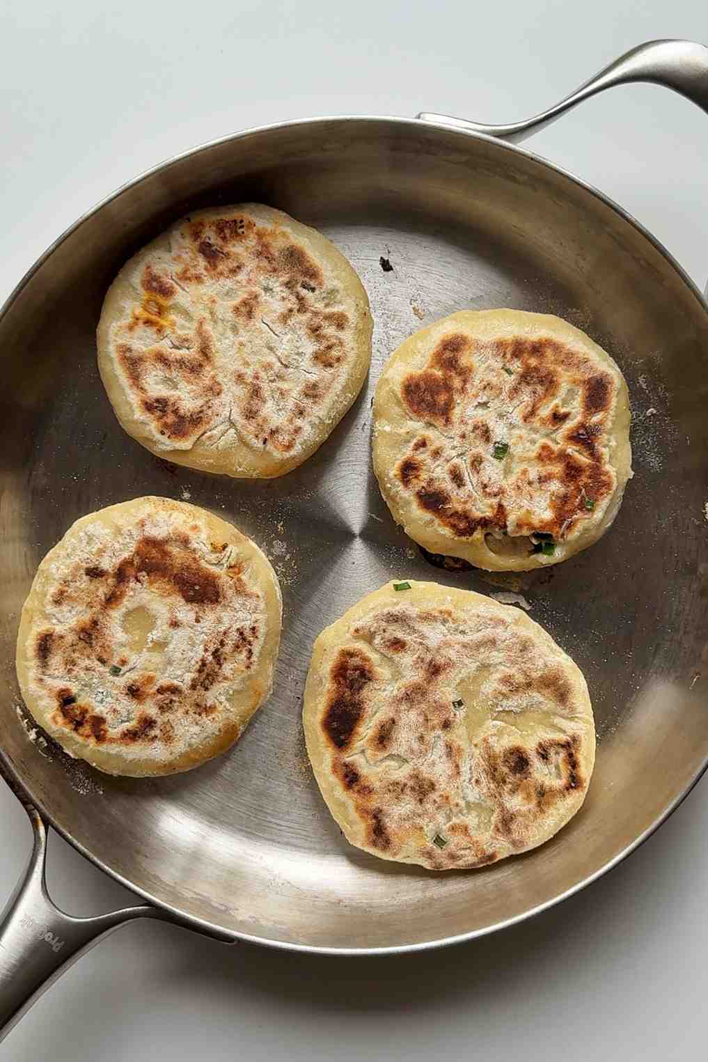 Frying fire chicken stuffed flatbreads in a pan.