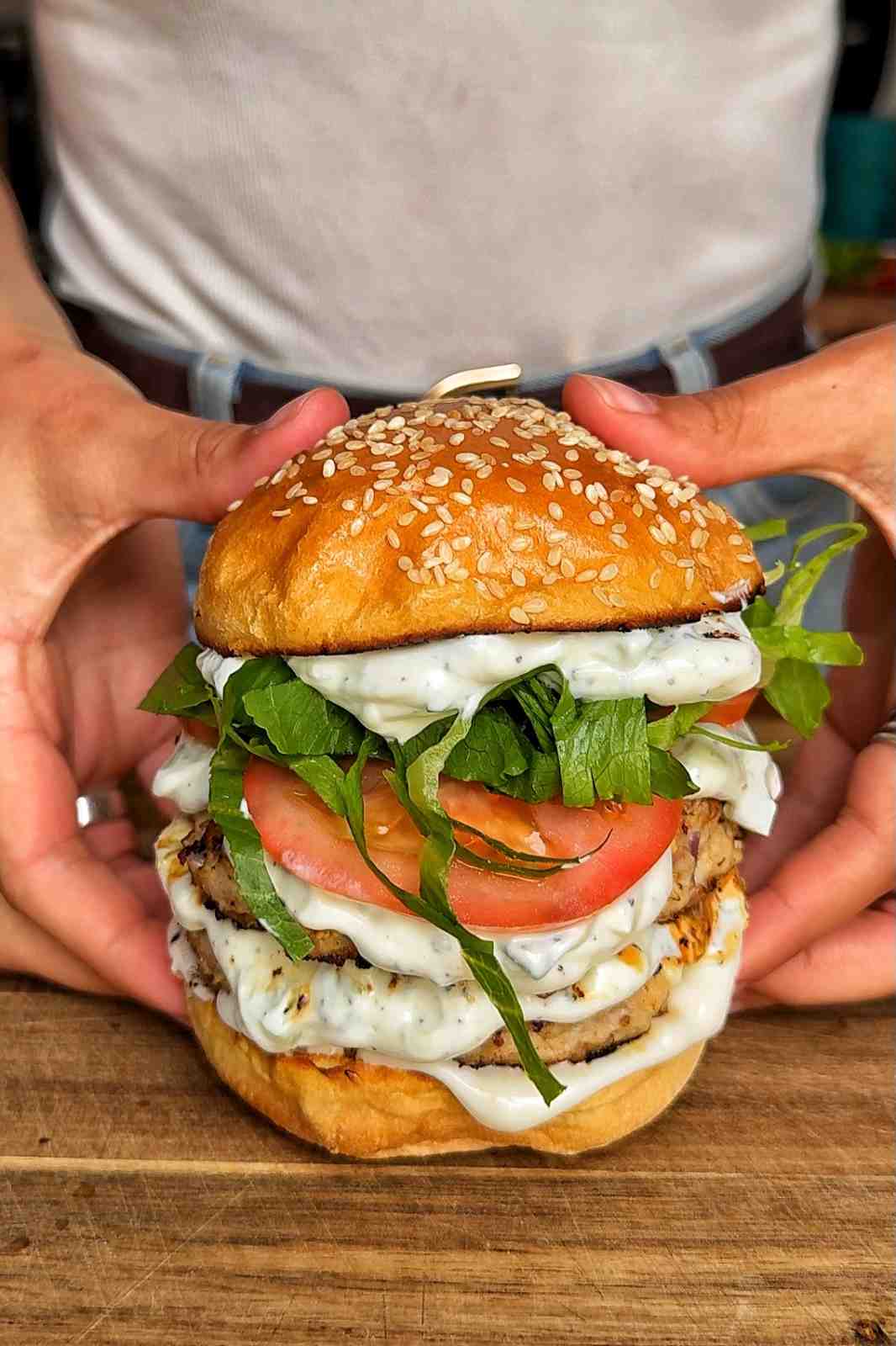Showing greek chicken burgers to the camera.