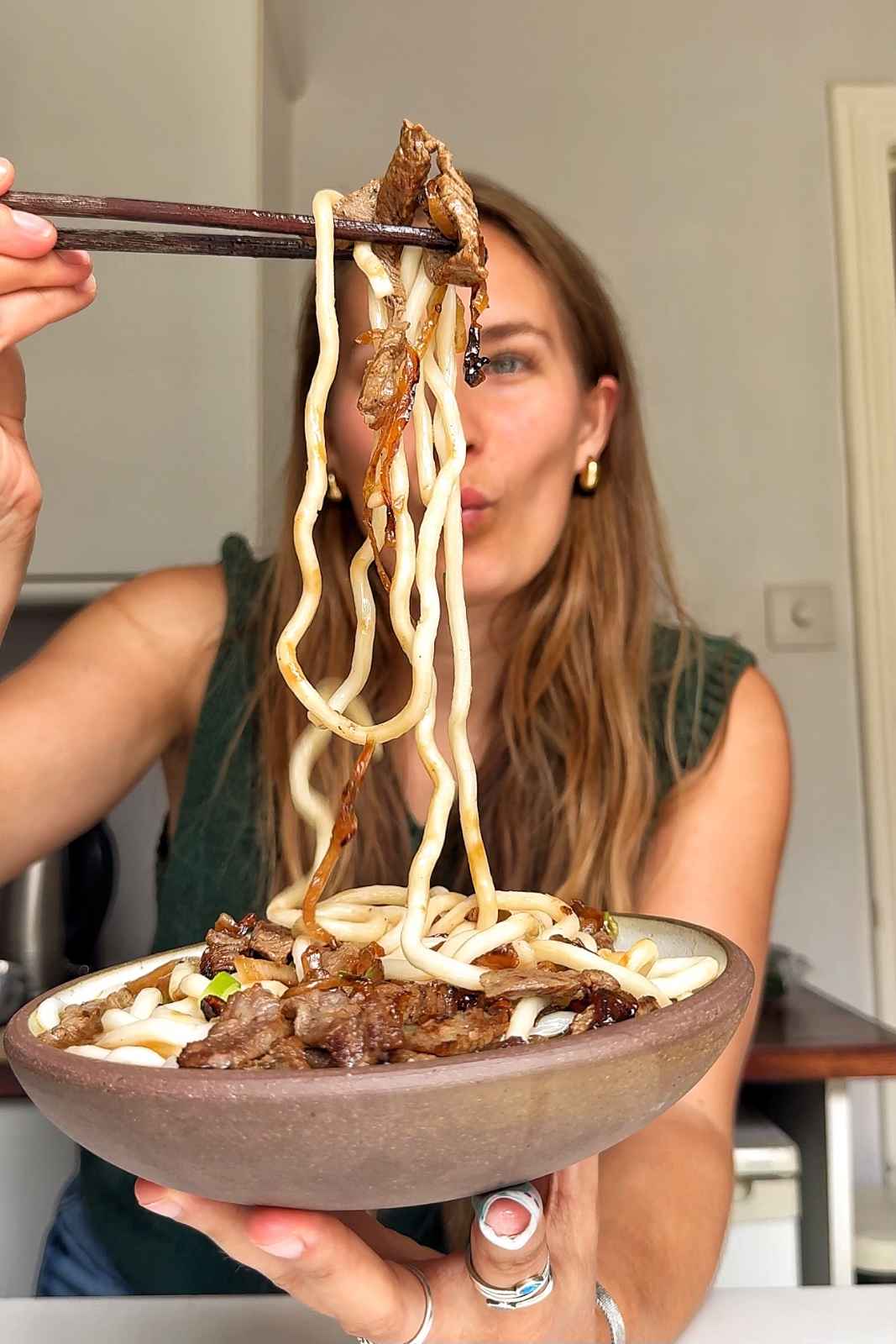 Emily Roz holding up beef udon noodles