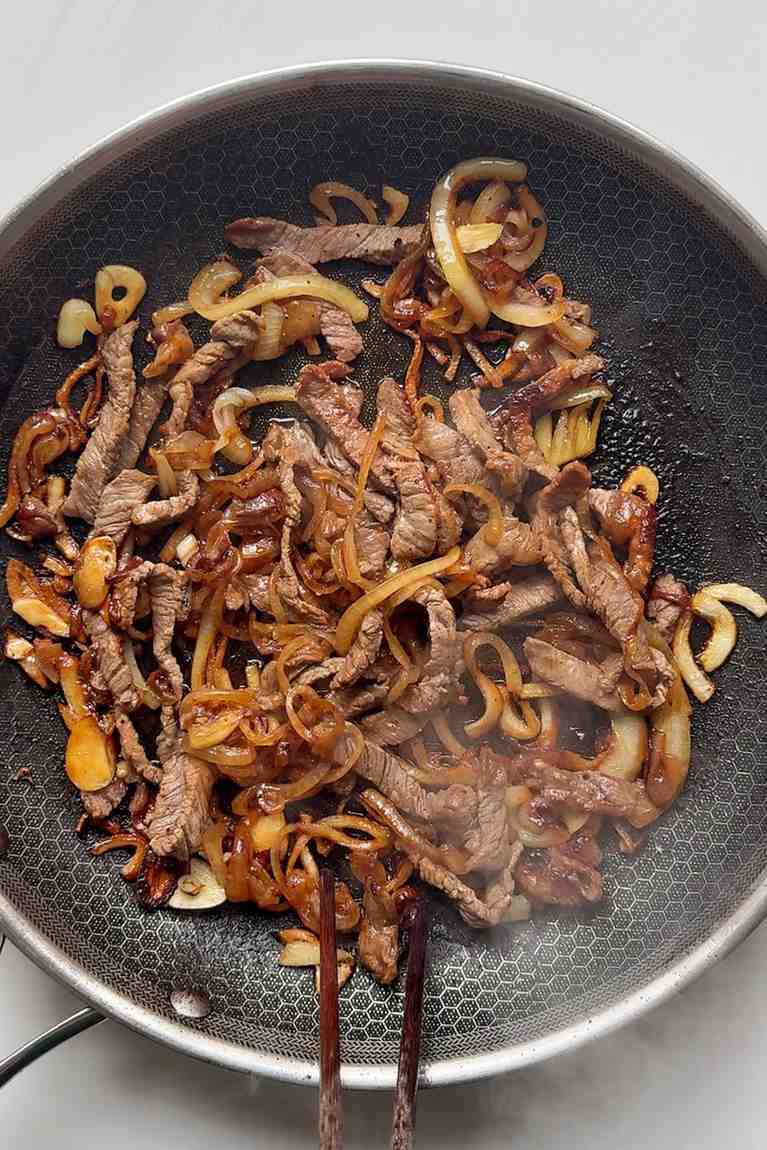Frying beef with onions until caramelised.