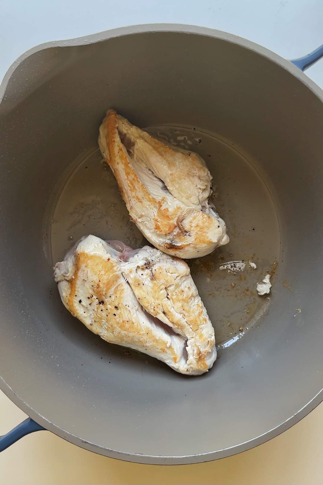Frying chicken breast in a large pot.