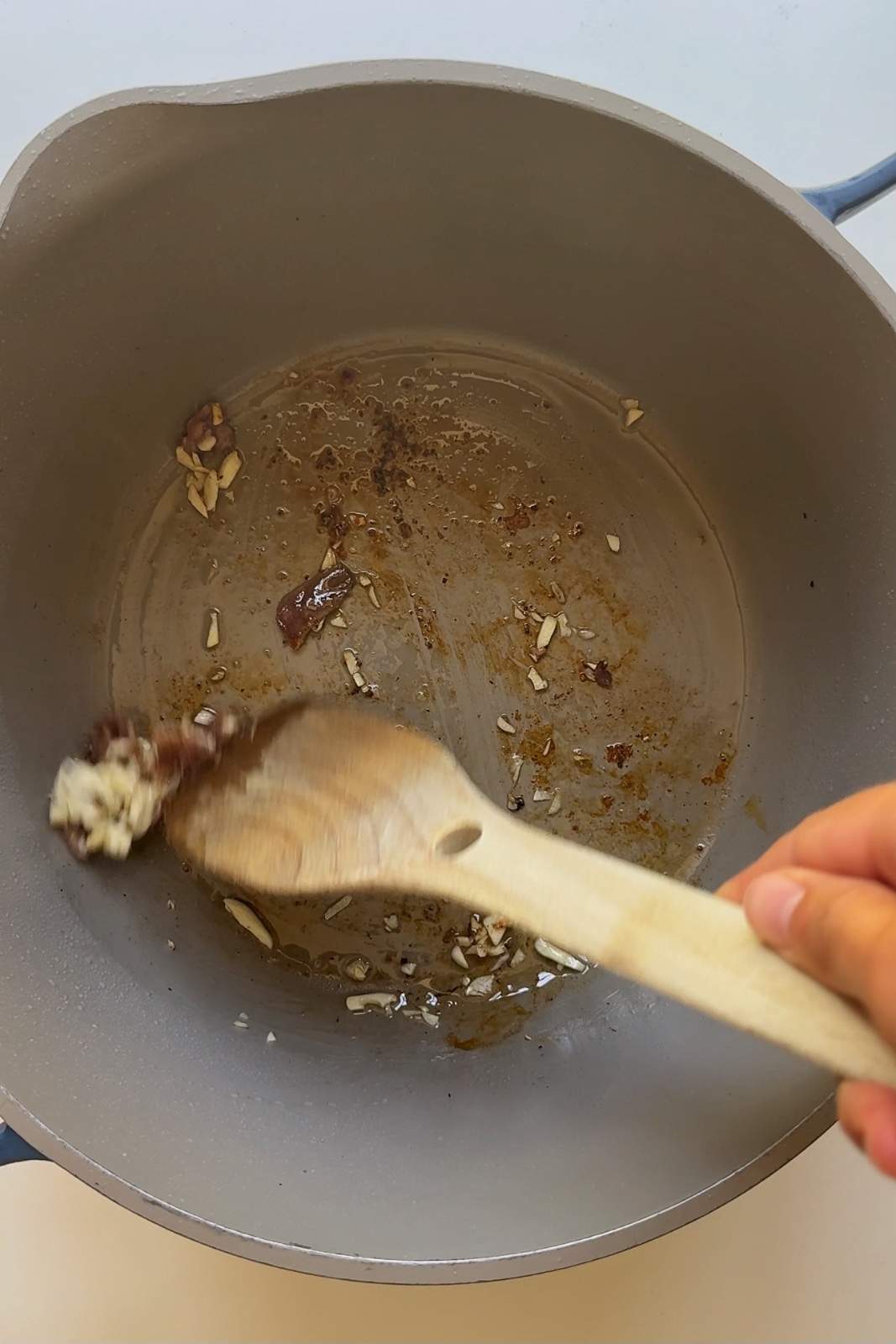 Frying garlic and anchovies in a large pot.