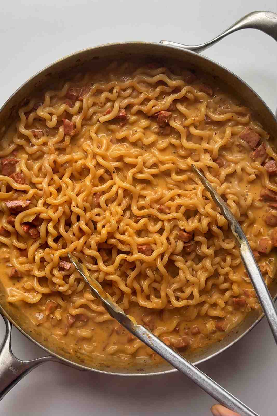 Chorizo pasta cooking in a pan.