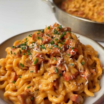 a bowl of creamy chorizo pasta topped with parmesan and chives