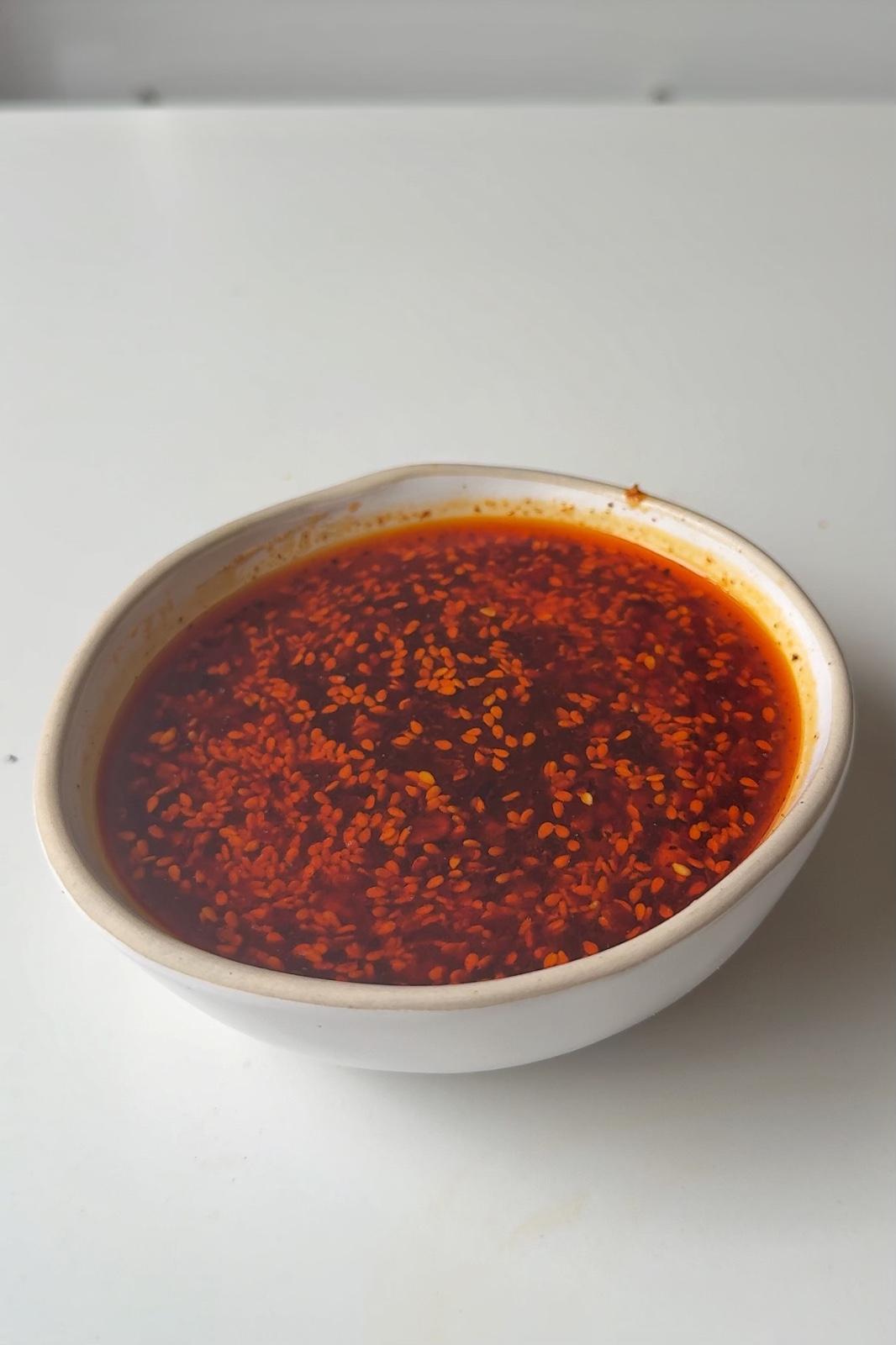Chilli oil chicken broth in a white bowl.