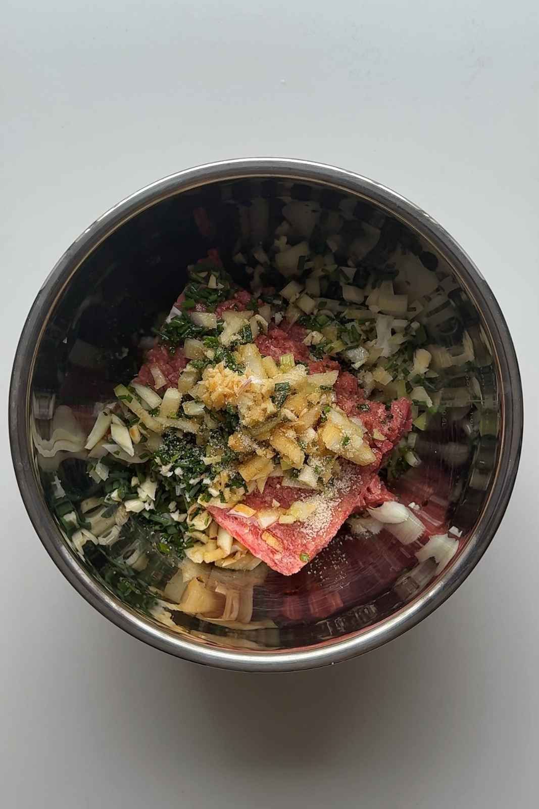 Dumpling filling mixture in stainless steel bowl.